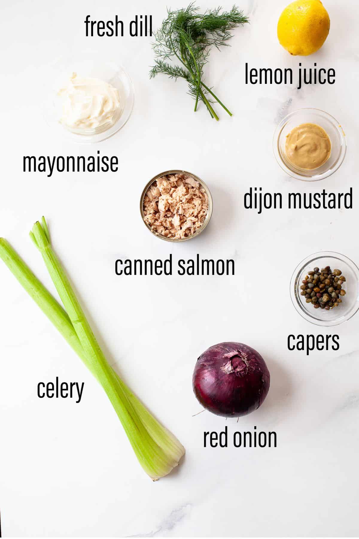 graphic of ingredients for canned salmon salad on marble surface with black text overlay